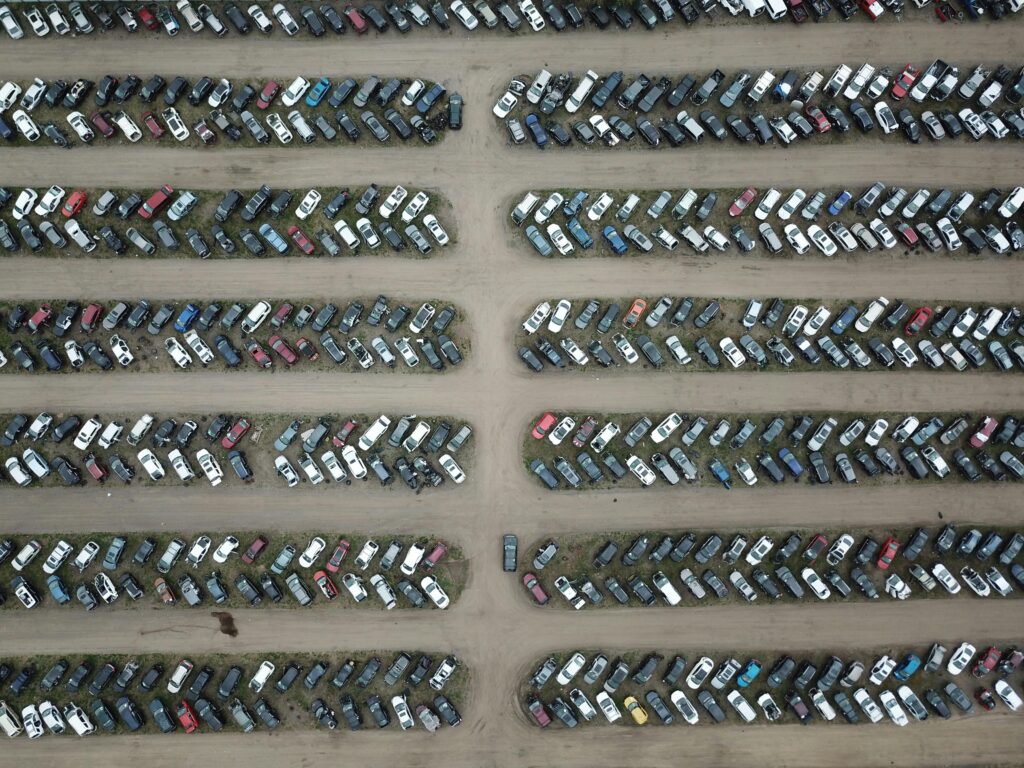 High angle view of numerous vehicles in an organized car lot, showcasing variety and structure.